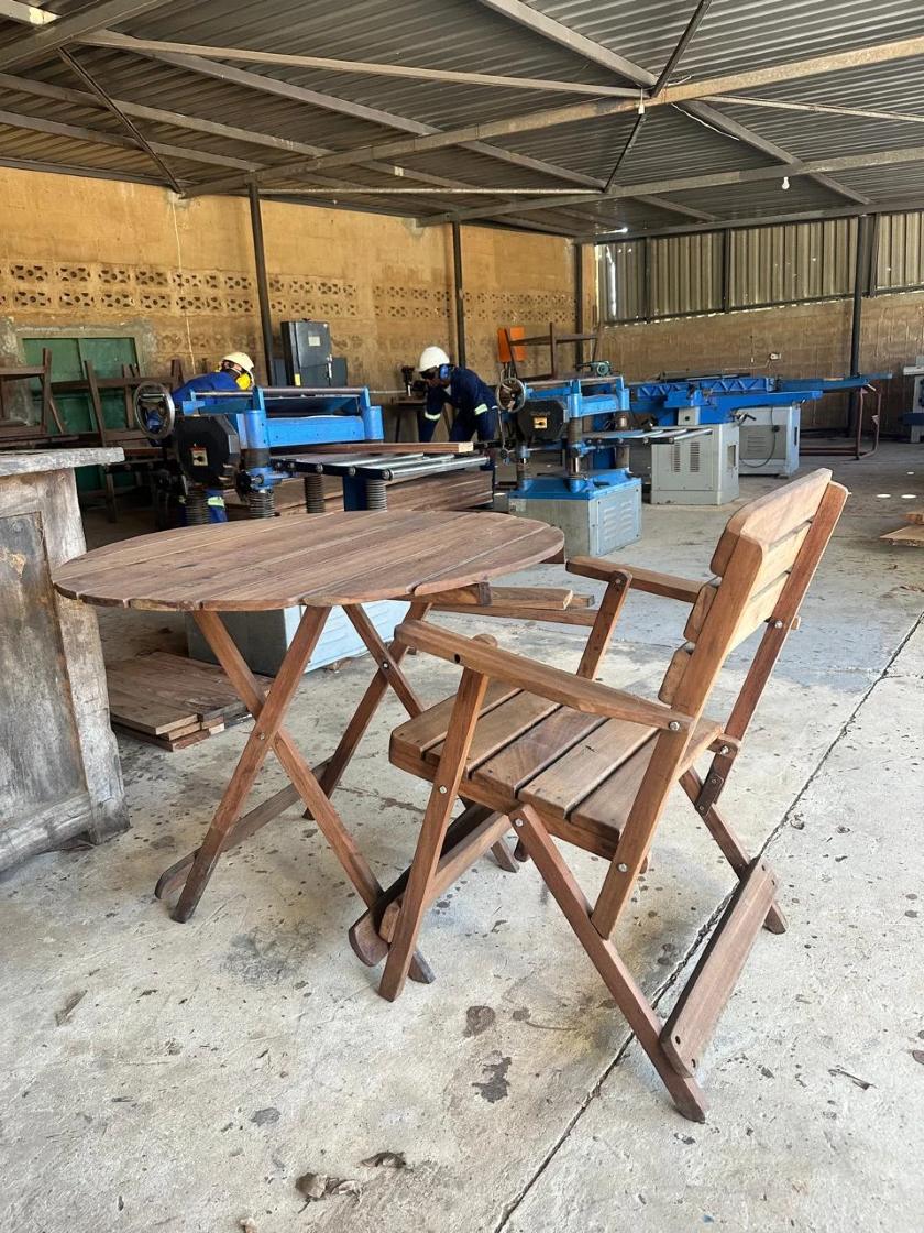 Carpenters at work behind a finished table and chair