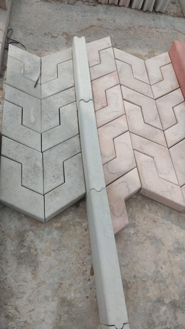 Grey and pink interlocking pavers laid in a pattern with a kerb