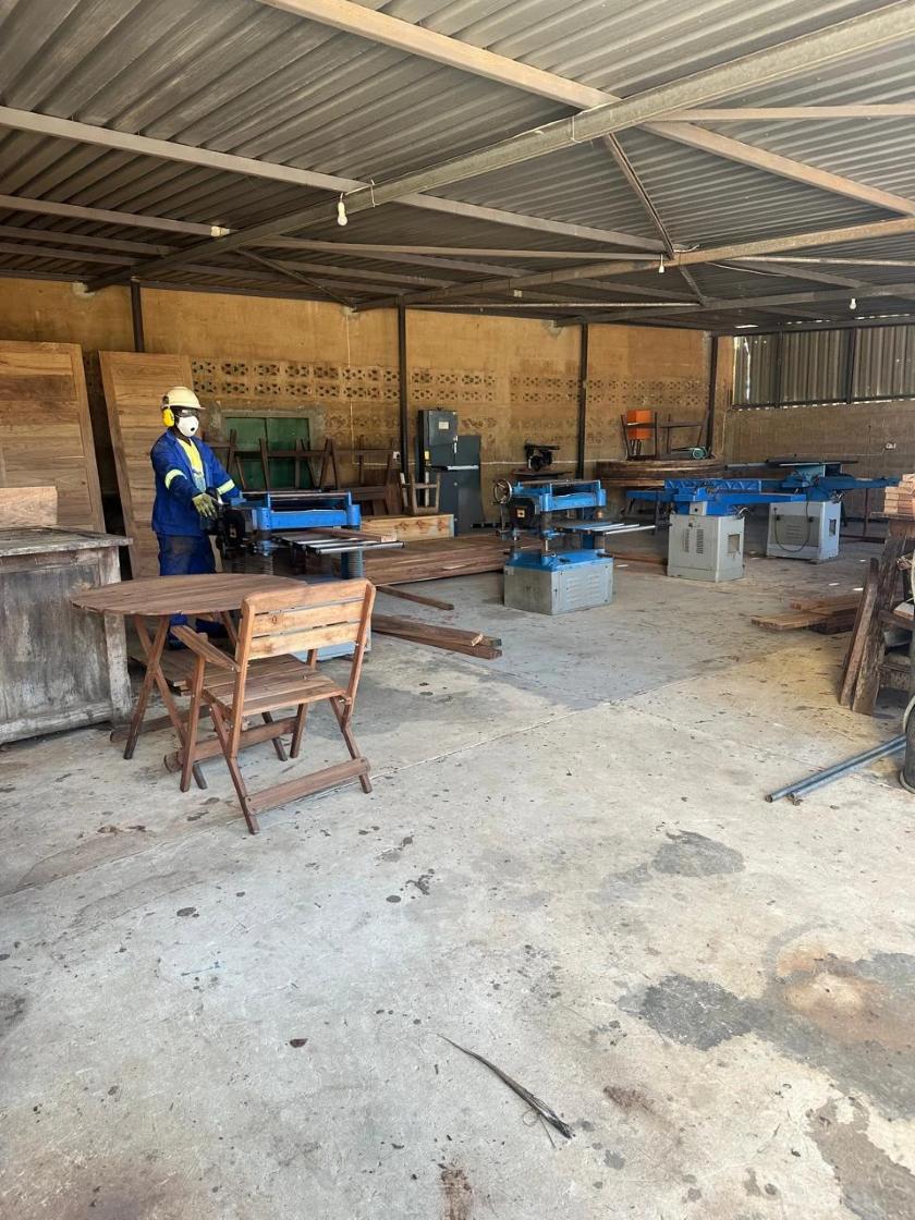 Carpentry workshop with planing machines, a finished table and a chair